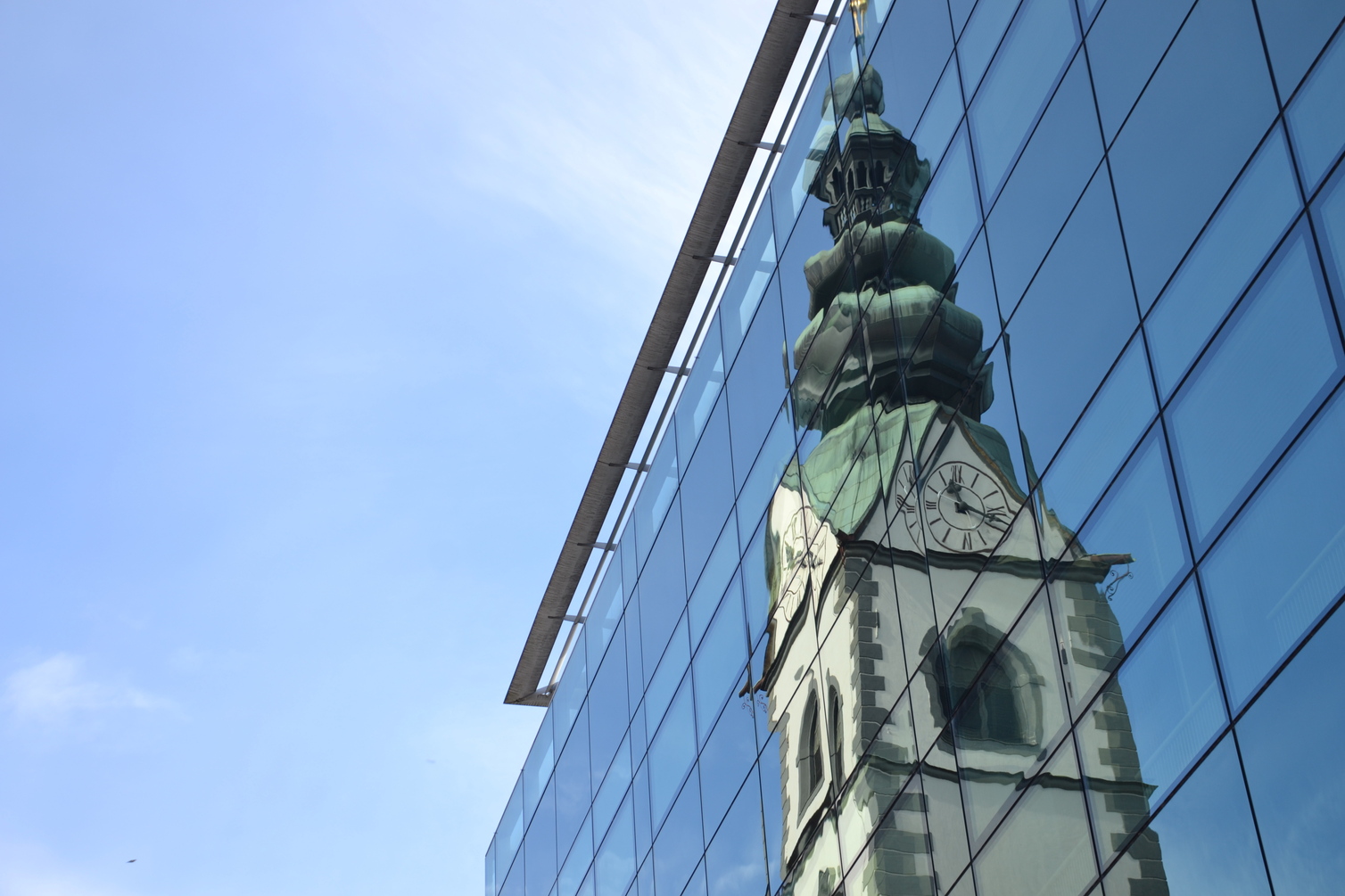 Klagenfurter Dom, der sich in Glasfassade spiegelt